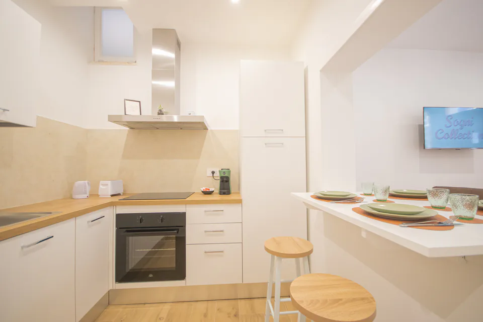Cucina con forno e penisola apparecchiata