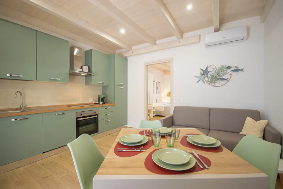 Cucina, tavola apparecchiata e divano letto