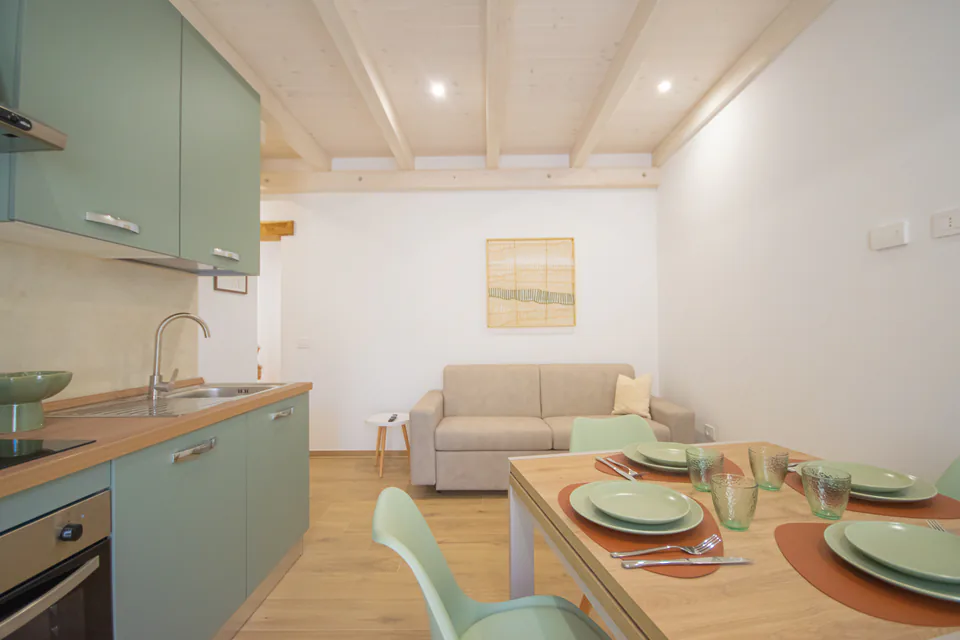 Cucina, zona pranzo e divano letto