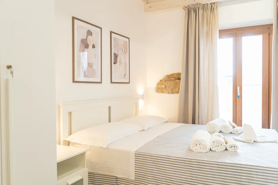 Letto matrimoniale e porta finestra