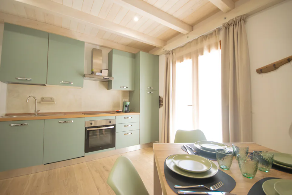 Cucina con forno e tavola apparecchiata